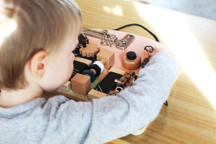 Drewniana motoryczna tablica edukacyjna z zamkami i obracającymi się elementami Small Foot 12392