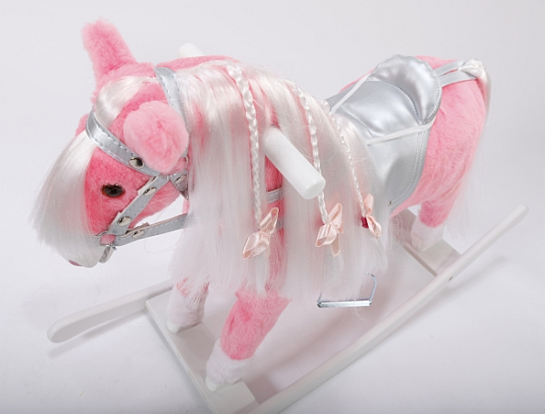 Różowy koń na biegunach z kokardkami w srebrnej uprzęży